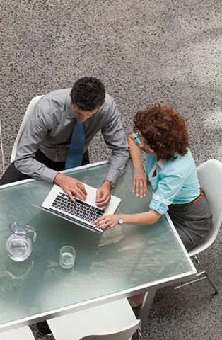 Colleagues working at table on laptop